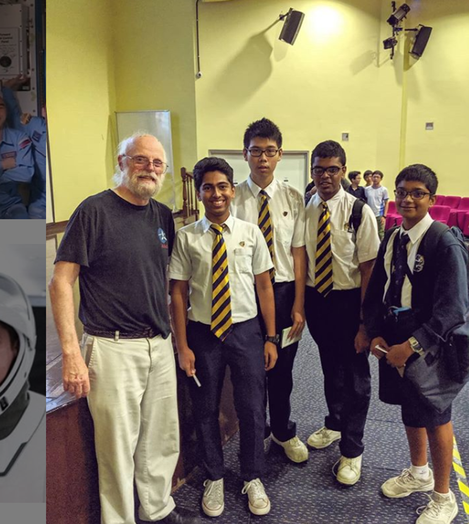 Four male students in white school uniforms pose with an older adult male in casual clothing, likely a guest speaker, in an indoor setting.